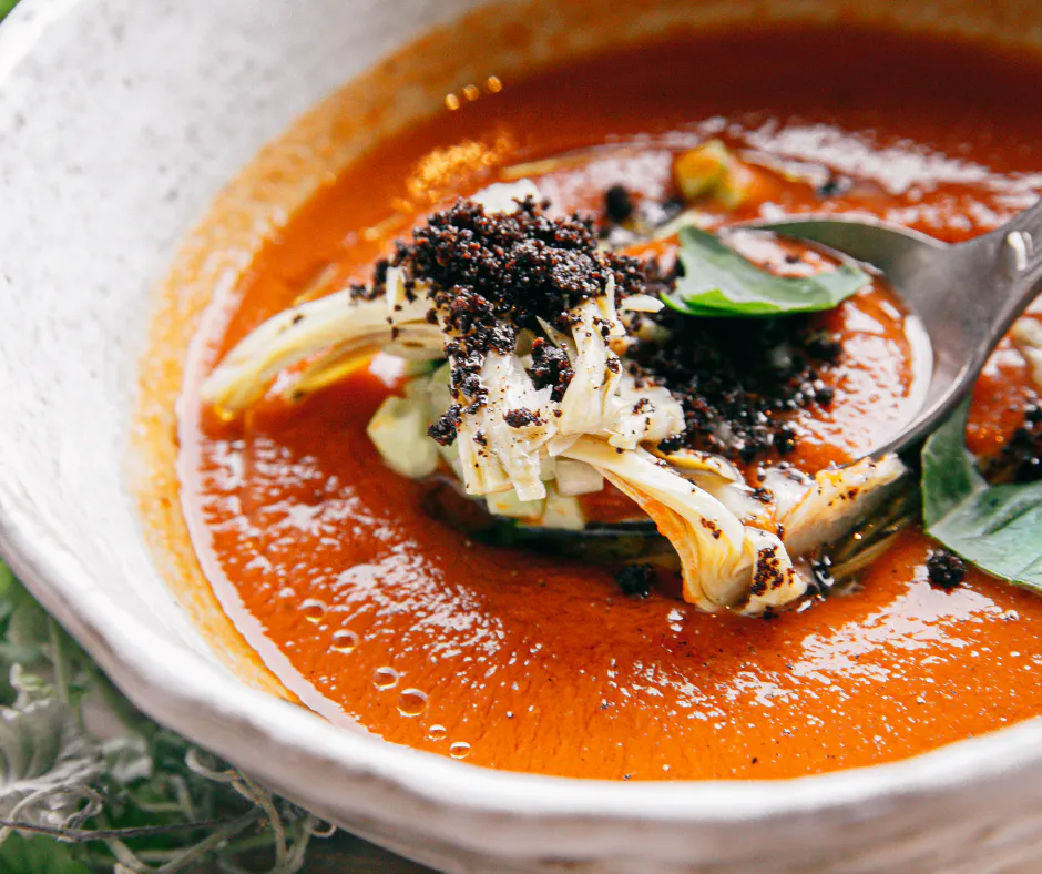 Bowl with stainless steel spoon in cold gazpacho soup